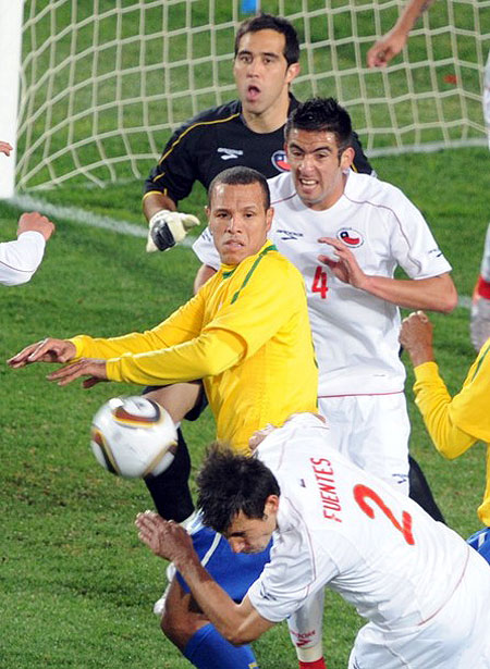 Chile's defender Ismael Fuentes (bottom) heads the ball as Brazil's striker Luis Fabiano (C) and Chile's defender Mauricio Isla (R) Chile's goalkeeper Claudio Bravo (top) look on during their 2010 World Cup round of 16 football match at Ellis Park stadium in Johannesburg, South Africa, on June 28, 2010